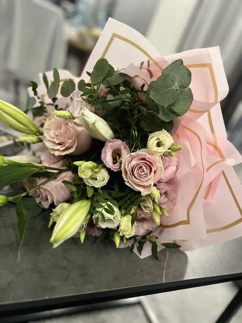Buchet pastel cu trandafiri și eustoma, în hârtie roz cu margine aurie